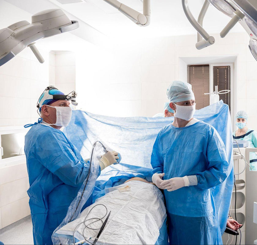 Two surgeons look at a computer monitor.